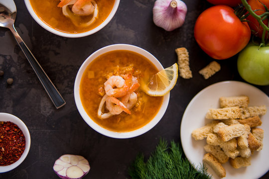 Lentil soup with seafood. Red soup with shrimps and squid top view