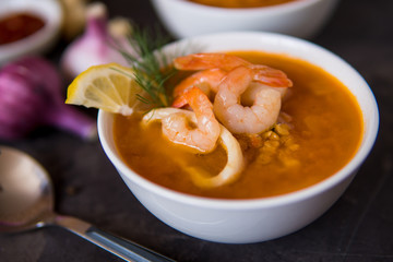 Lentil soup with seafood. Red soup with shrimps and squid, copy space