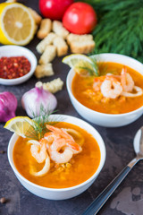 Lentil soup with seafood. Red soup with shrimps and squid, copy space