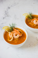 Lentil soup with seafood. Red soup with shrimps and squid