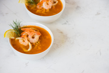 Lentil soup with seafood. Red soup with shrimps and squid