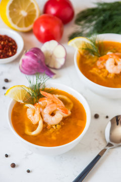 Lentil soup with seafood. Red soup with shrimps and squid, copy space