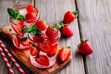 Hibiscus strawberry rhubarb iced tea with mint. Ice cold summer cocktail or lemonade in mason jar