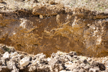 Cut of soil with different layers on constraction site