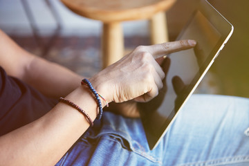 Man sitting home and using digital tablet for surfing web internet. Man using gadget at apartment. Horizontal. Blurred background