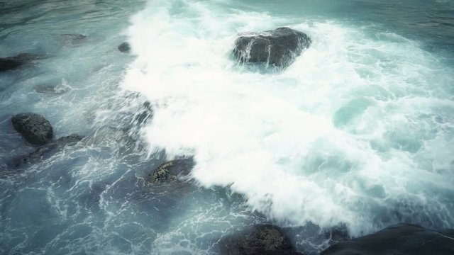 Dramatic Huge waves break on the coastal stones of the Italian Riviera. Slow motion.