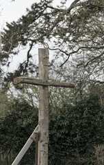 Bare wood outdoor christian cross in the wood religious concept