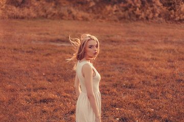 Fototapeta na wymiar Outdoor fashion photo of young beautiful lady in autumn landscape 