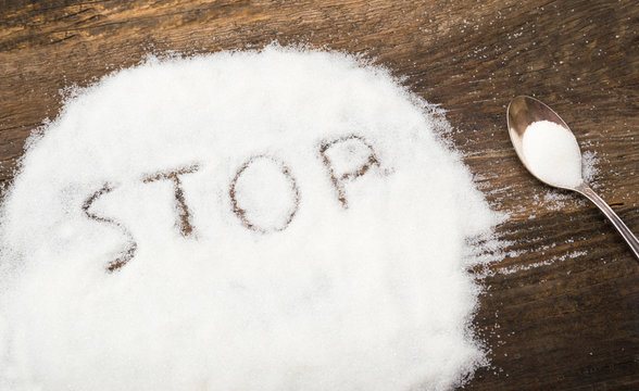 Stop sign made of granular sugar. The picture illustrates the harm of eating sugar and salt, as well as dependence on flavoring additives.