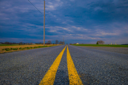 Close Up Of Yellow Line In Urban Road With A Gorgeous Cloudy Day