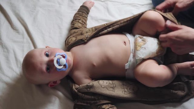 The father changes the baby diaper. The child is happy. 4k