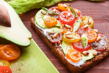 bruschetta with avocado, cherry tomatoes, blue cheese sauce, shallots. concept of a healthy breakfast with ingredients nearby