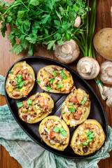 Baked potatoes in jacket stuffed with bacon, mushrooms and chees