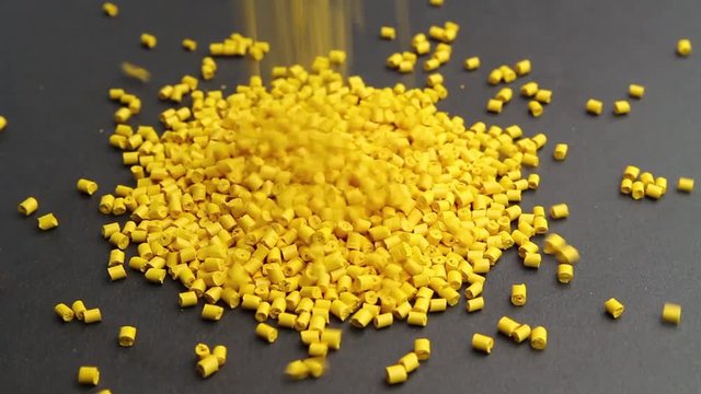 Plastic pellets crumbles to the table . Plastic raw materials in granules for industry. Polymer resin.