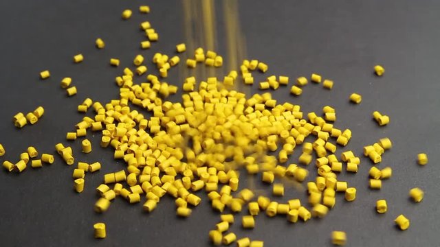 Plastic pellets crumbles to the table . Plastic raw materials in granules for industry. Polymer resin.