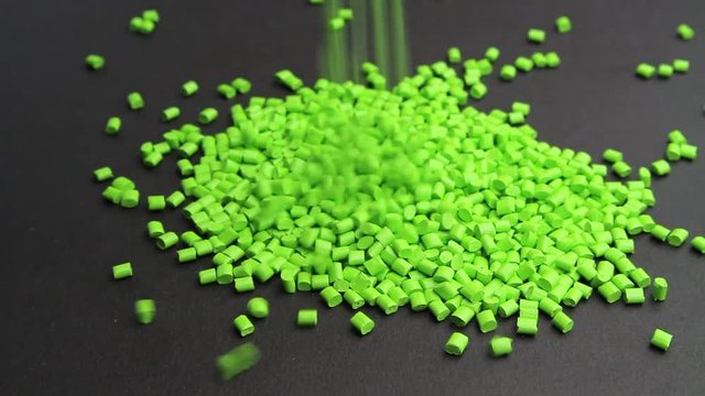 Plastic pellets crumbles to the table . Plastic raw materials in granules for industry. Polymer resin.