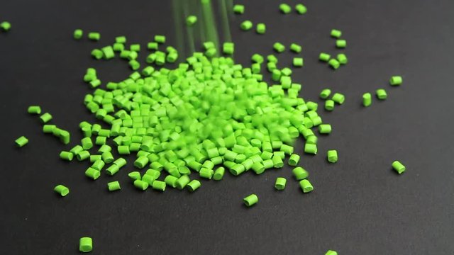 Plastic pellets crumbles to the table . Plastic raw materials in granules for industry. Polymer resin.