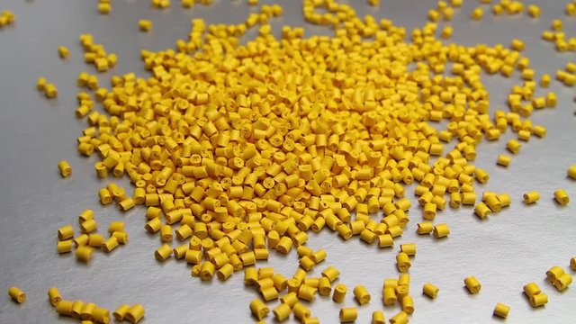 Plastic pellets crumbles to the table . Plastic raw materials in granules for industry. Polymer resin.