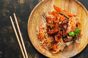 Korean dish of noodles with fried meat close-up. View from above.