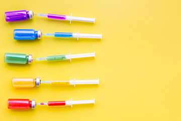 Fototapeta premium Vaccination, immunization. Syringe and bottle with medicament on yellow background top view copy space