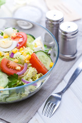 fresh spring salad of vegetables on a white wooden table.