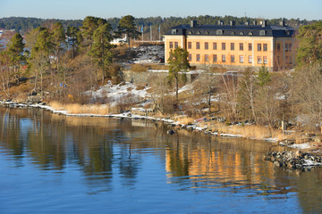 Stockholm archipelago. Old yellow house on rocky island. Spring