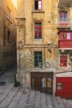 Malta, Valletta, traditional house building facade with sandstones and covered balconies