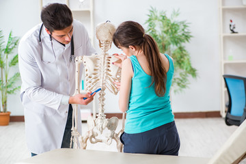 Doctor showing type of injury on skeleton to patient