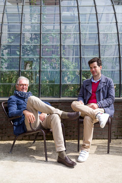 Father and son in front of greenhouse in park