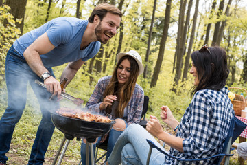 Naklejka na ściany i meble Group of friends making barbecue and having fun outdoor