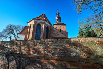  Brick, medieval wall and the Gothic parish church in Gniezno.