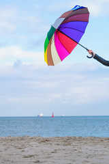 Woman hand holding colorful plastic umbrella