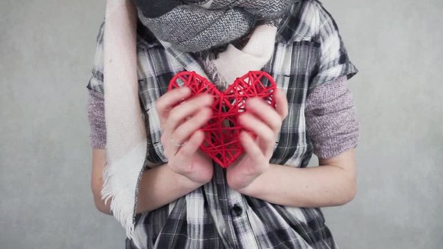 Mujer sujetando un coraz&oacute;n fingiendo un latido