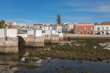 View of the old Roman bridge and Gilao river in the city of Tavira at low tide, Portugal