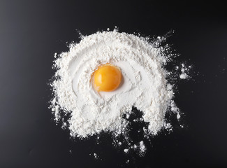 flour and egg yolk on black background