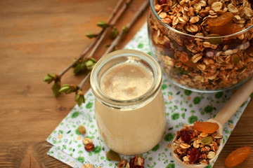 Yogurt in a glass jar and granola in the background