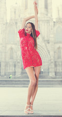 Obraz premium portrait of sexy young woman in red dress walking in the old city