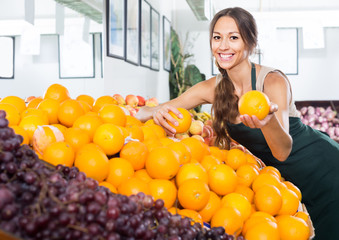 Obraz premium Woman seller holding orange in hand