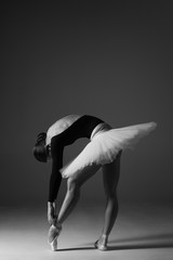 Young beautiful ballerina is posing in studio