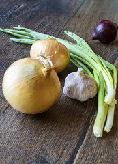 Garlic and onions on wooden background, selective focus