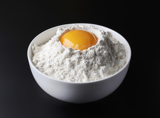 flour and egg yolk on black background