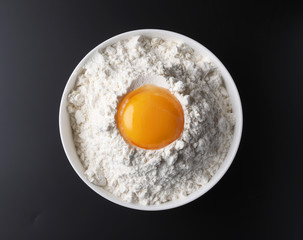 flour and egg yolk on black background