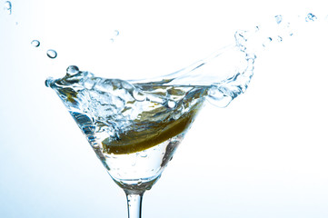 Glass of water with lemon with splash with copy space on white