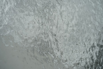 Surface of window after winter storm covered with rain, sleet, and ice