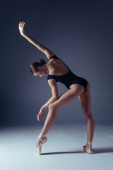 Young beautiful ballerina is posing in studio