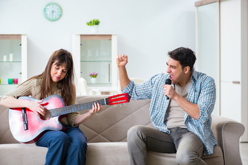 Young family singing and playing music at home