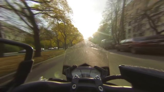 Speeding motorcycle on city road, first view
