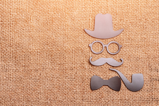 Daddy's day concept, magnets hat, glasses, mustache, Smoking pipe and bow tie on fabric background for bags
