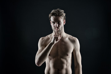 Bodybuilder show silence finger gesture. Sportsman with sexy chest and belly. Bearded man athlete...