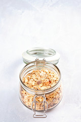 Jar with homemade granola or oatmeal muesli with nuts and dried fruits. Healty diet breakfast, vegan or vegeterian food concept